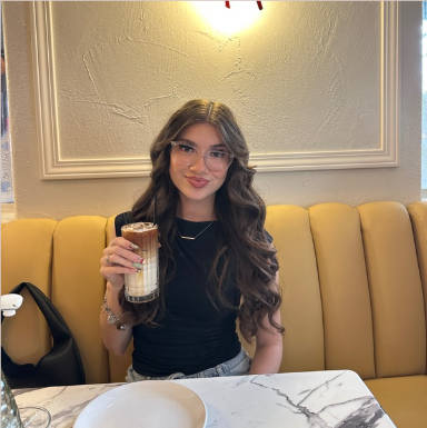 Baliah at a cafe holding a latte